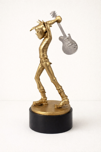 Gold 3D printed award sculpture of a teenage cancer trust kid playing a guitar on a black base against a white background