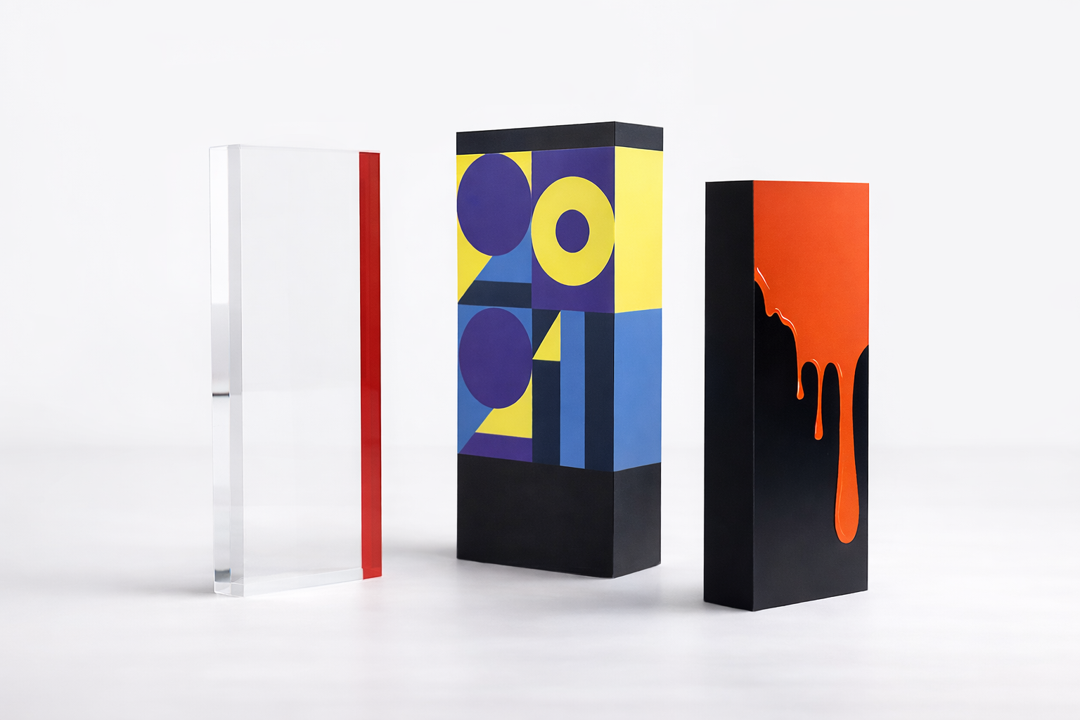 Three tall acrylic awards with geometric shapes on a white background