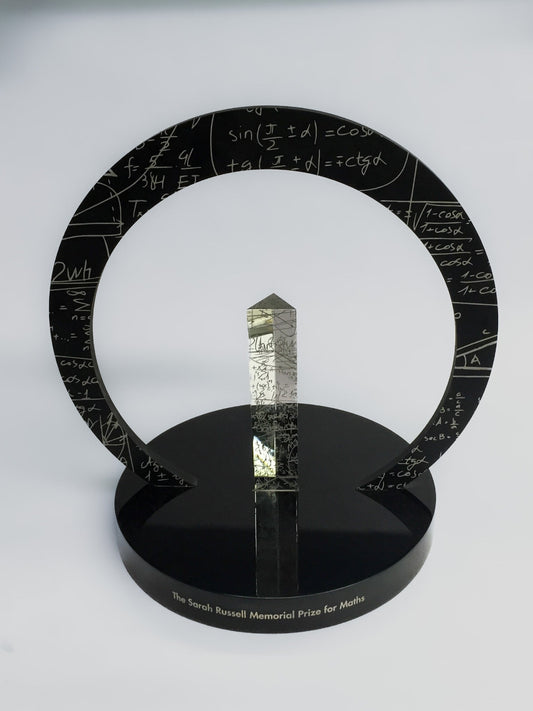 Decorative award with mathematical equations on a circular ring and black base