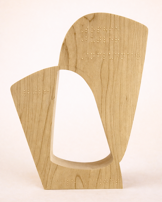 The back of a wooden cut out award for scope with a special Braille inscription.