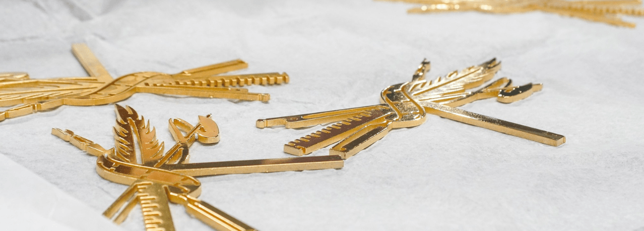 Laser-cut brass award components, hand-finished before assembly in our studio