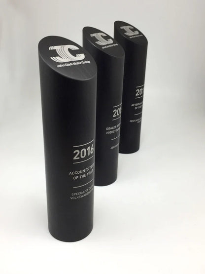 Three black cylindrical awards with text on a white background