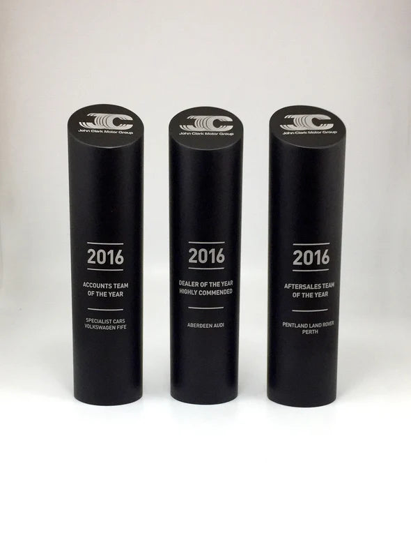 Three black cylindrical awards with '2016' and text on a white background