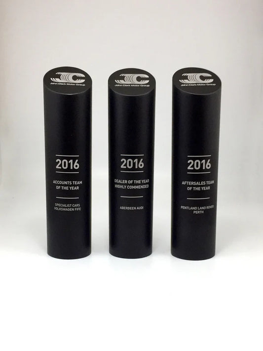 Three black cylindrical awards with '2016' and text on a white background