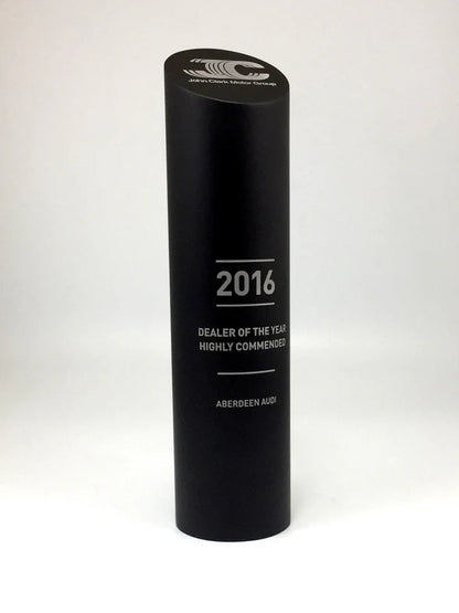 Black cylindrical award with text on a white background