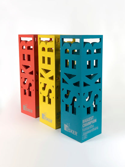 Three colorful metal Esker awards on a white background
