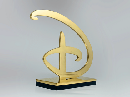 Bespoke brass Disney award, laser-cut signature logo on polished brass and black plinth base