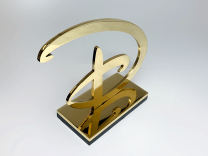 Brass Disney signature award viewed from above, showing laser-cut script detail on plinth base