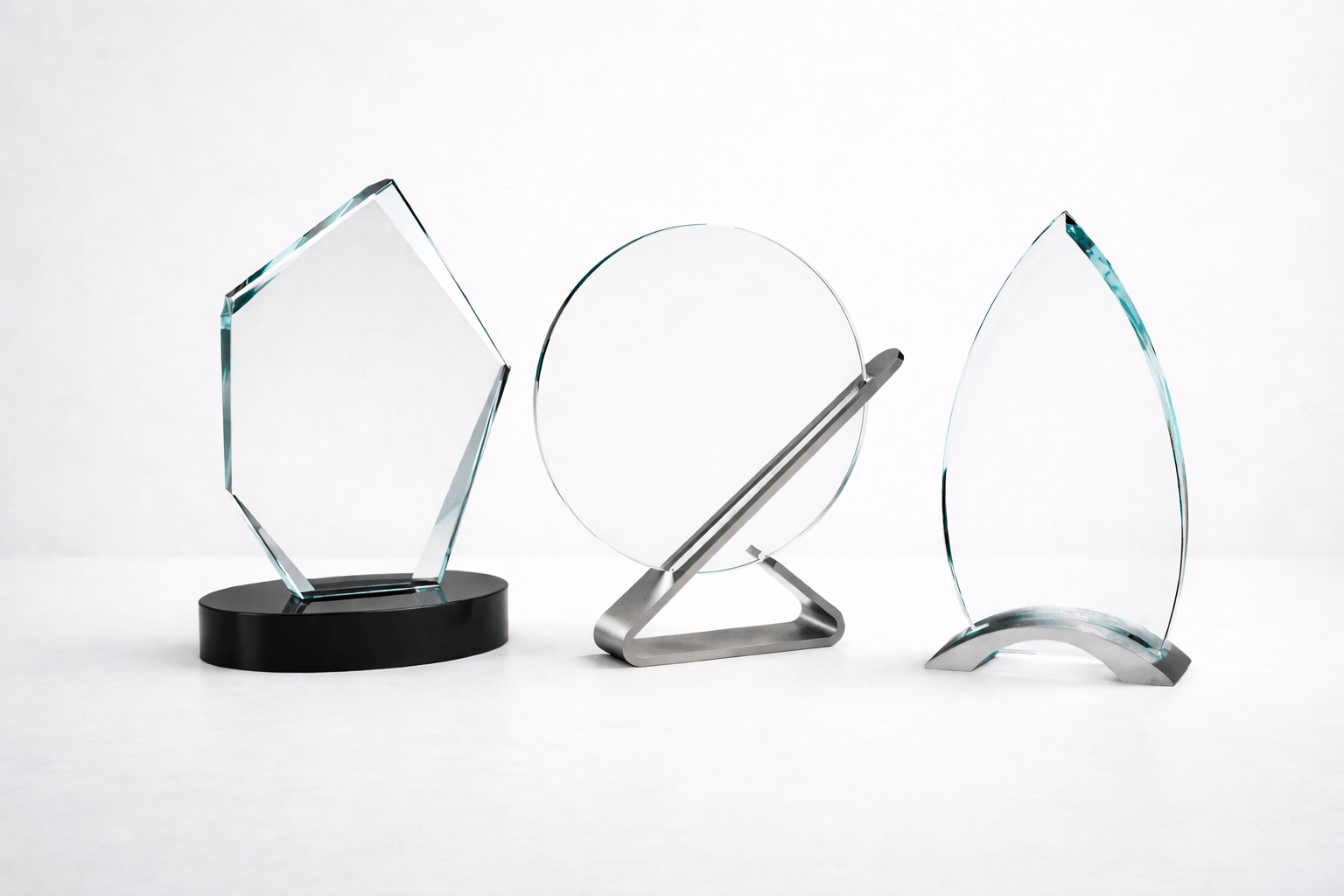 Three modern glass awards on a white background