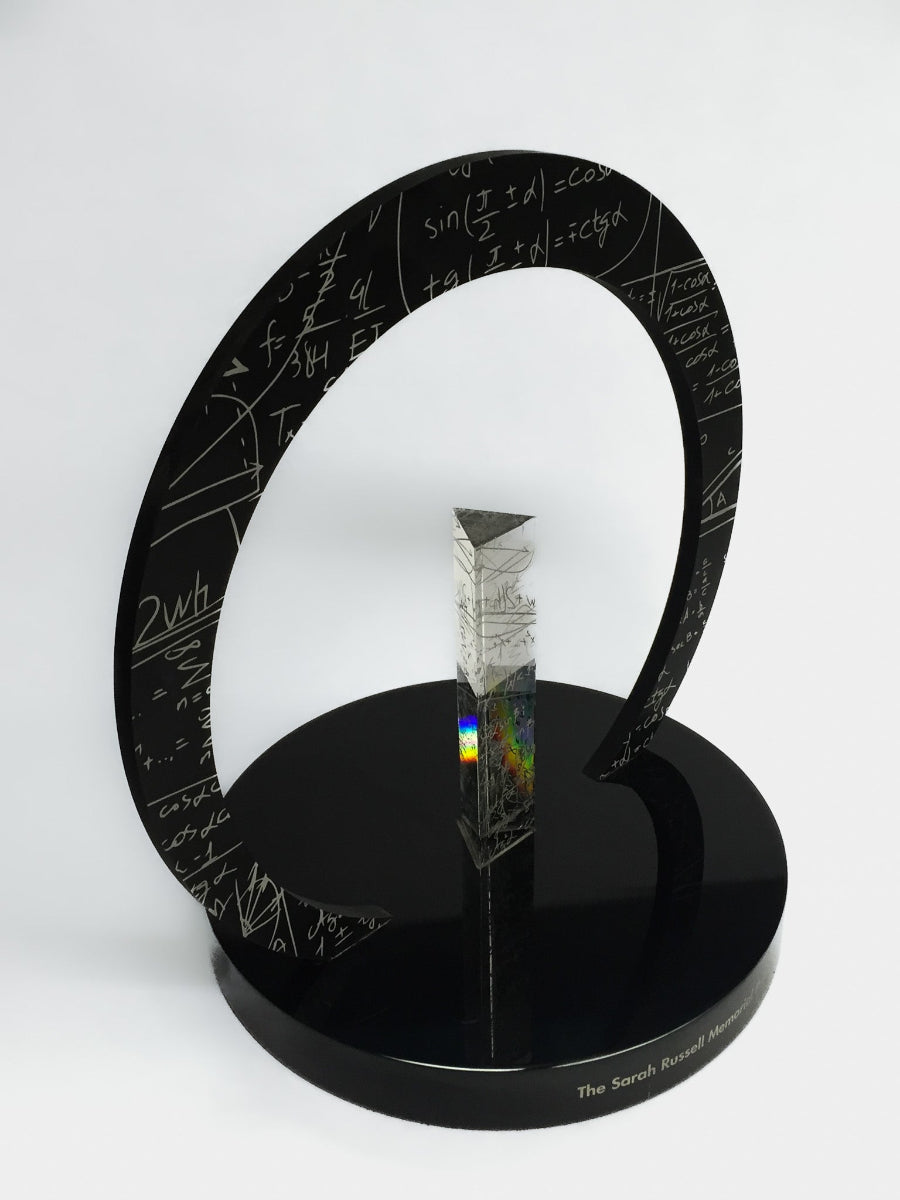 Crystal award on a black stand with mathematical equations, on a white background