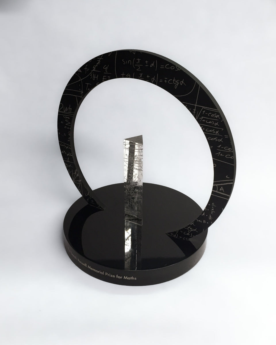 Black circular award with a reflective center on a white background