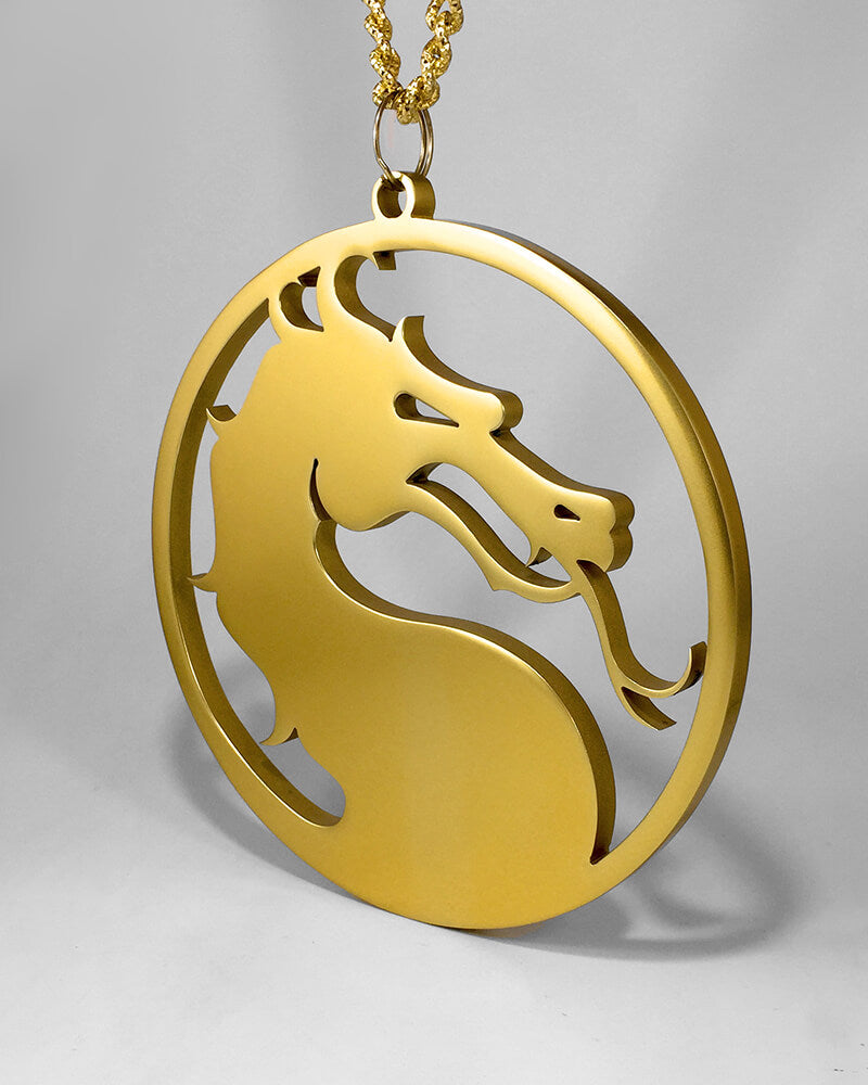 Gold pendant medal shaped like a Mortal Kombat dragon's head in profile within a circular frame, on a gold rope chain.