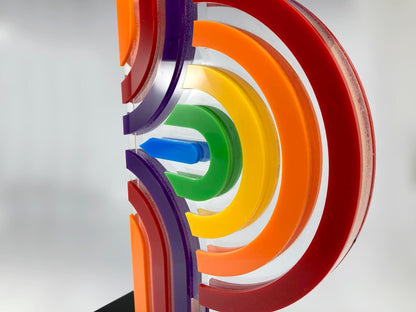 Close-up of layered coloured acrylic pride award showing rainbow arc detail, red orange yellow green blue violet
