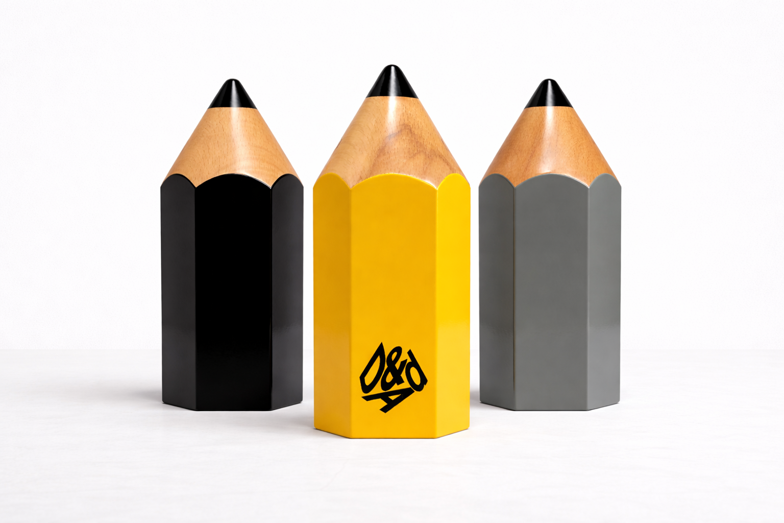 Three pencil-shaped DA&D with black, yellow, and gray hexagonal bodies on a white background.
