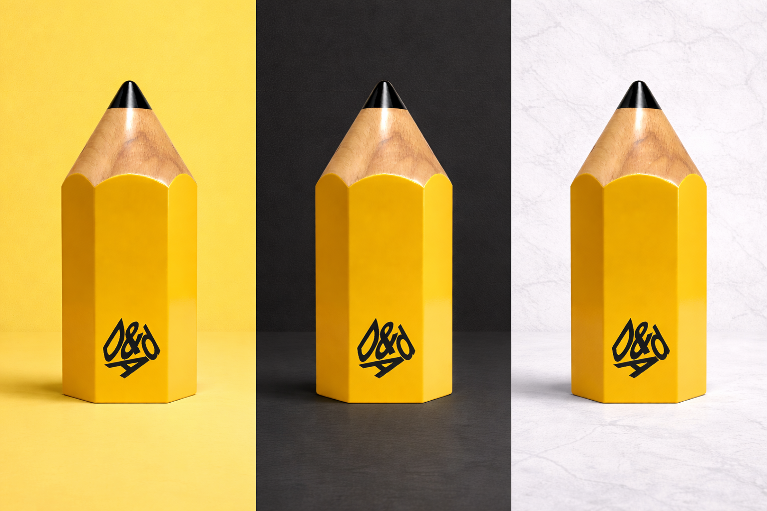 Three yellow pencil awards with black logo on a yellow, black, and white background