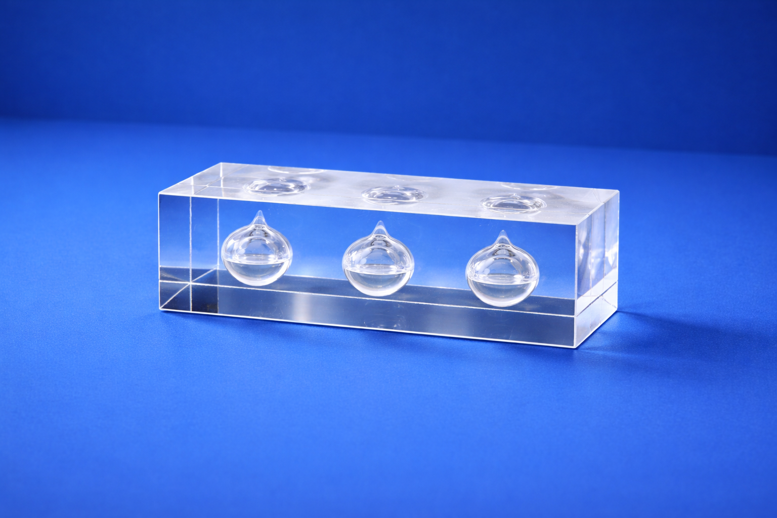 Clear rectangular deal toy with three droplet-shaped inserts on a blue background