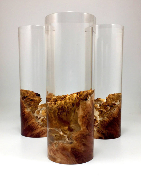 Three cylindrical awards with resin containers with a natural wood interior on a white background