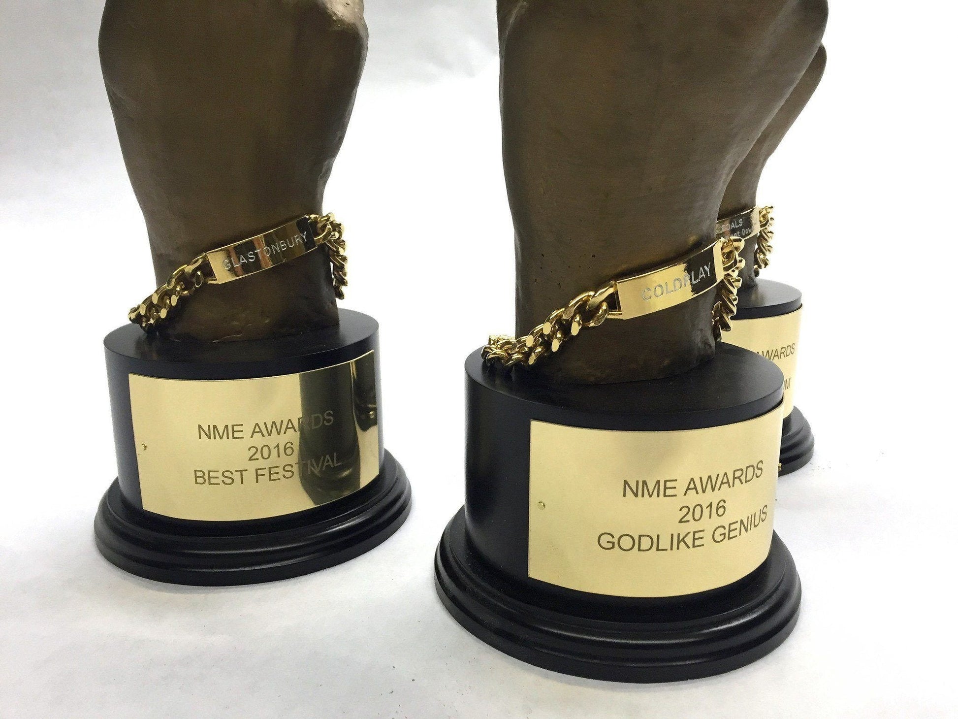 Close up of engraved award with "NME awards 2016 best festival Glastonbury" on a white background