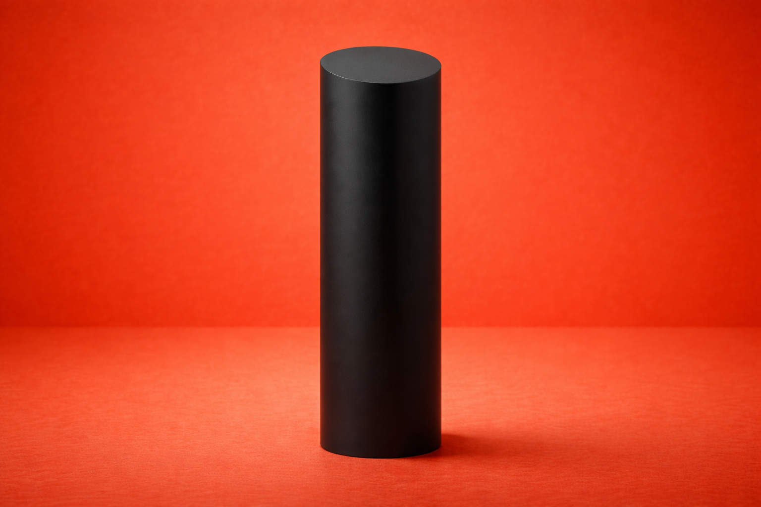 Black cylindrical object on a red background